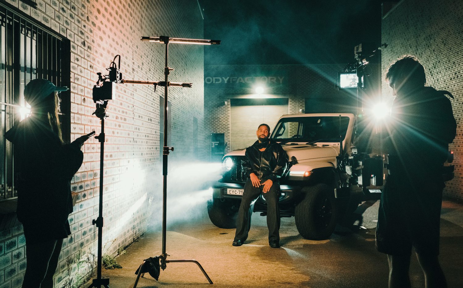 Night shoot beside a Jeep with smoke and a camera rig