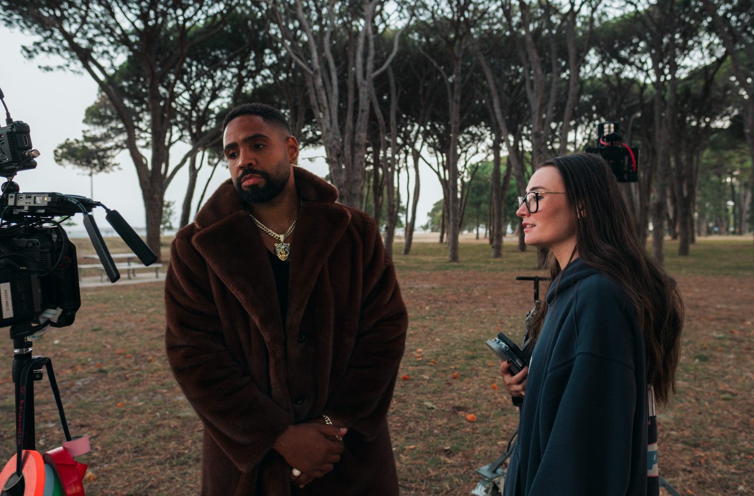 Directing the singer in a fur coat in a pine park